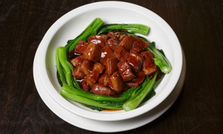 The braised pork with soy surrounded by greens.