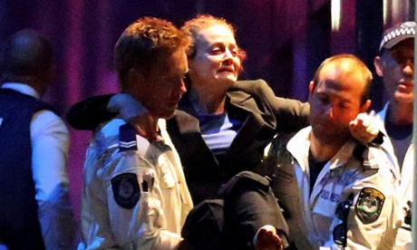 A woman is carried out by police from the Lindt Cafe, Martin Place following a hostage standoff on December 15, 2014 in Sydney, Australia. 