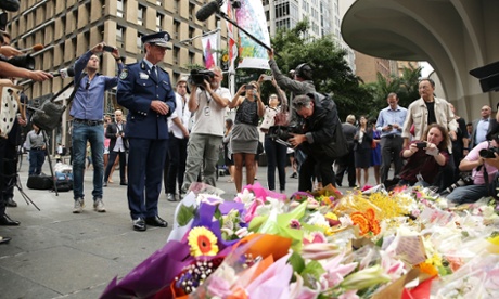 New South Wales Police Commissioner Andrew Scipione stands in front of flowers left as a sign of respect at Martin Place.