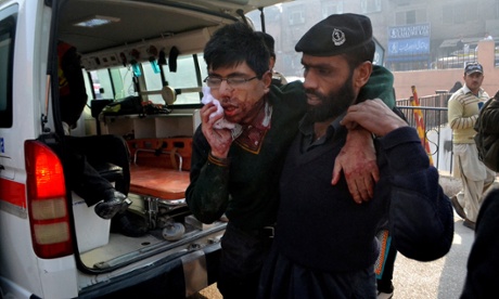 A hospital security guard helps a student injured in the shootout.