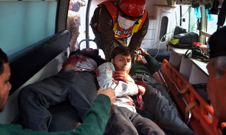 Pakistani rescue workers take students injured in the shootout to hospital.