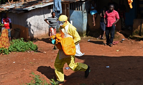 A Sierra Leonean health worker carries the body of a child for burial