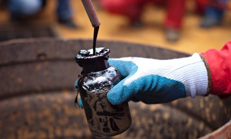 A worker collects crude oil sample at an oil well operated by Venezuela's state oil company PDVSA 