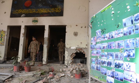 Pakistani soldiers walk amidst the debris in an army-run school a day after an attack by Taliban militants in Peshawar.
