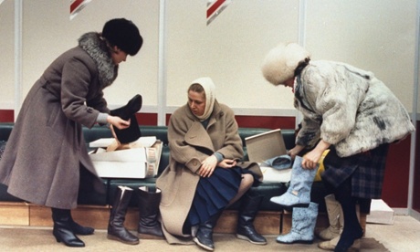 Trio of women trying on boots, shopping for imported shoes, at Luxe (Lyuks) department store in suburban Moscow, in 1989.
