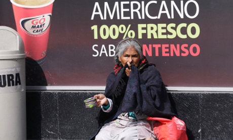 A woman begs on the sidewalk outside a coffee shop in Mexico City.