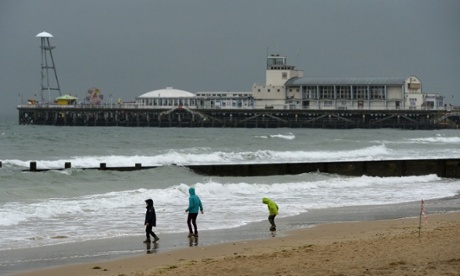Summer's over - a family brave the weather on a near deserted Bournemouth Beach on Bank Holiday Monday as wind and rain arrive