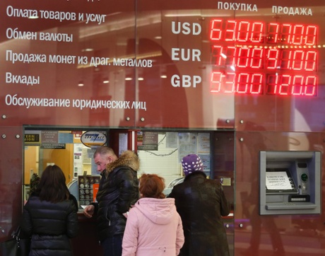 People queue at an exchange office in front of electronic information board displaying currency exchange rates, in Moscow, 17 December 2014.