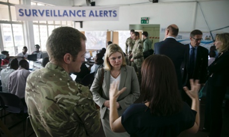 Britain's International Development Secretary Justine Greening (C) talks to workers and British Army personnel during a visit to the Western area emergency response centre in Freetown December 16, 2014.