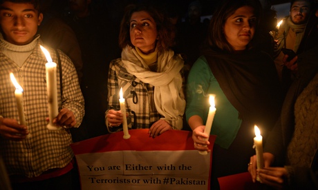People light candles for school victims in front of the radical Red mosque in Islamabad