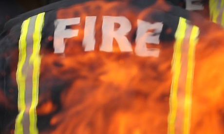 Firefighter standing in front of a fire