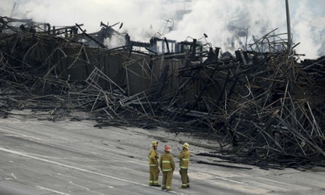 Firefighters stood on lanes of the 110 freeway near smoldering hot spots