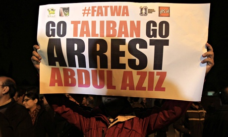 A man holds a sign during a protest near the Red Mosque in Islamabad