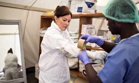 A British health worker puts on protective clothes at a Red Cross clinic in eastern Sierra Leone