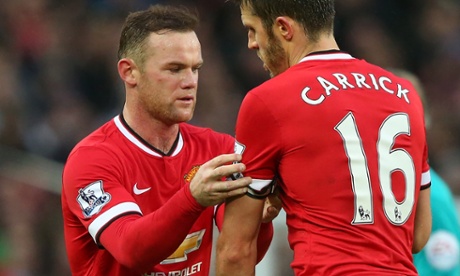 MANCHESTER, ENGLAND - DECEMBER 14:  Wayne Rooney of Manchester United passes the Captain's armband to Michael Carrick during the Barclays Premier League match between Manchester United and Liverpool at Old Trafford on December 14, 2014 in Manchester, England.  (Photo by Alex Livesey/Getty Images)English Premier LeagueFootballSoccerClub SoccerEnglish Soccer ClubBallTeam Sport