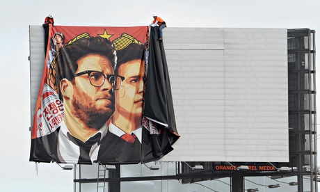 Workers remove a banner for The Interview from a billboard in Hollywood after Sony announced it canc