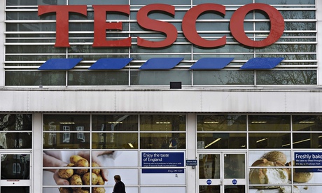 Woman walks past a Tesco supermarket
