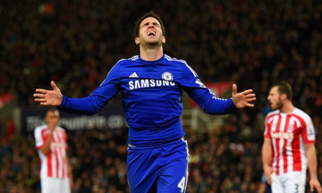 Stoke City players look dejected as Cesc Fabregas celebrates.