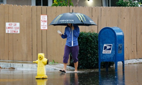 A resident of San Diego, California, makes his way through ponding water 12 December 2014. Weather forecasters expect a dry holiday conditions there for the next few days.