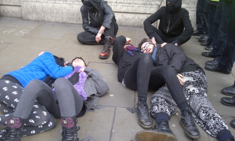 Protesters lie on the ground next to police outside the old RBS building near Trafalgar Square.