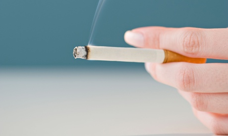 Woman holding lit cigarette