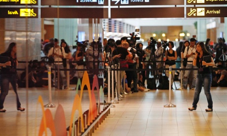 Journalists crowd the waiting area for next-of-kin and relatives of passengers onboard AirAsia flight QZ8501 at Changi Airport in Singapore.