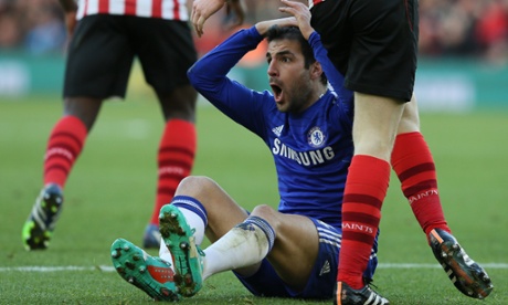 Cesc Fabregas holds his head after being booked for simulation.