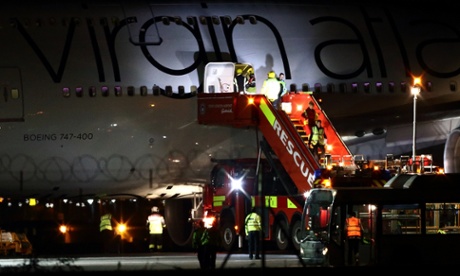 The flight crew are helped to disembark the Virgin Atlantic Boeing 747 at Gatwick airport.