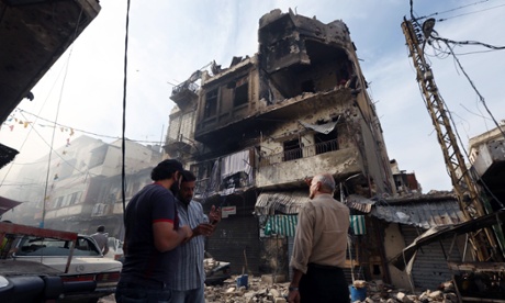 Men stand near buildings damaged due to clashes between the Lebanese army and Islamic militants in Tripoli.