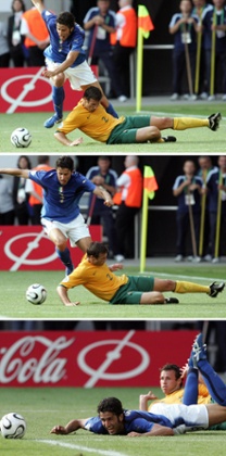 Fabio Grosso falls after fighting for the ball with Australian defender Lucas Neill.