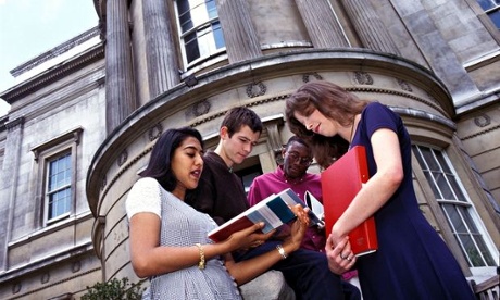 Group of university students standing chatting outside on campus.