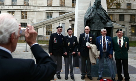 Veterans have their photograph taken next to the memorial following the unveiling ceremony.