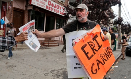 Doug Phaneuf hands a newspaper to a pedestrian while offering information to passersby about a rally for Eric Garner on Friday in Staten Island, New York.