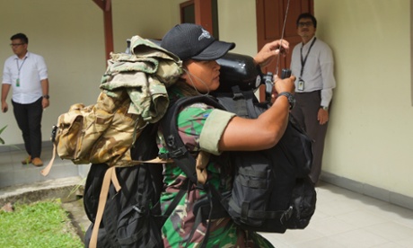 An Indonesian Navy diver takes scuba gear to a waiting aircraft on Bangka Island, Indonesia.