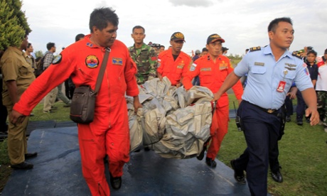 Indonesian air force crew members carry what is believed to be an emergency slide from the AirAsia plane.