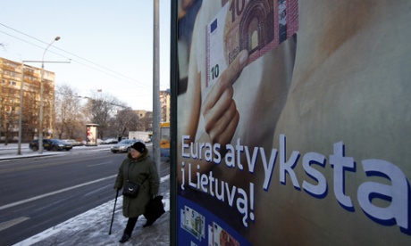 A woman walks past a poster reading 