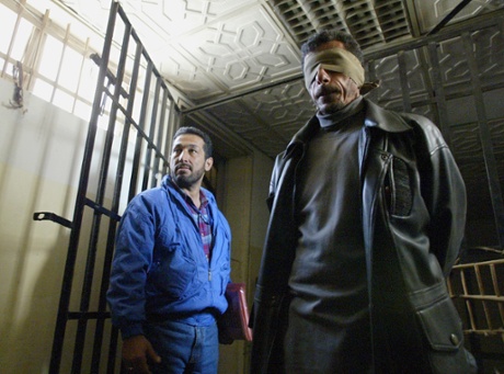 A December 2003 photo shows two unidentified members of Iraq's Hezbollah demonstrating how they were kept in captivity during Saddam's regime. Seven hundred Hezbollah militants were reportedly killed by the regime.