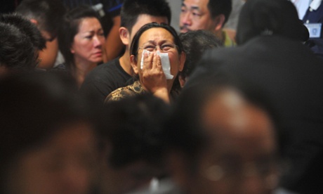 A woman cries after hearing the announcement that the objects found in waters were confirmed parts of AirAsia QZ8501 at Juanda International Airport on December 30, 2014 in Surabaya, Indonesia.