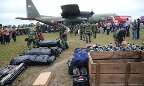 Members of the Indonesia marines unload their diving equipment as they arrive at Pangkalan Bun air base in Central Kalimantan on December 31, 2014, to join the operation to find the missing Malaysian air carrier AirAsia flight QZ8501.