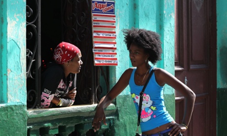 Two women chat at a window of a cafe in Havana, Cuba