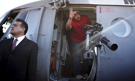Vigilante leader Luis Antonio Torres waves from inside a military helicopter