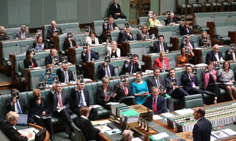 The opposition hold up a booklet titled 