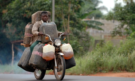 Man carrying oil on his motorcycle