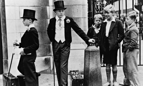 Local lads look on with curiosity at Harrow schoolboys outside Lord's for the cricket match with Eton in 1937