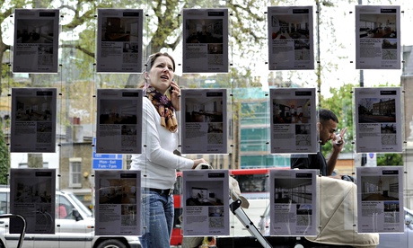 A woman stops to look in the window of an estate agent in Islington, north London