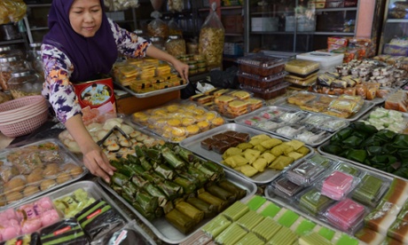 A vendor arranges a display of fresh traditional snacks for sale at a market in Jakarta on November 28, 2014. 