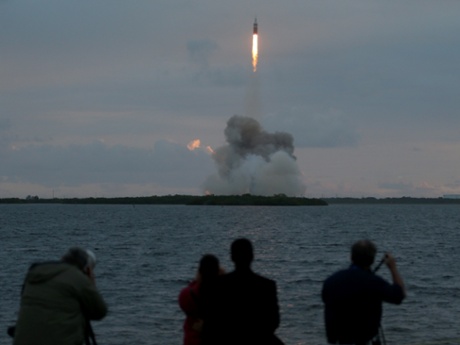 Spectators watch the Delta 4 rocket carrying Nasa's first Orion deep space exploration craft take off from the launch pad on December 5, 2014 in Cape Canaveral, Florida.