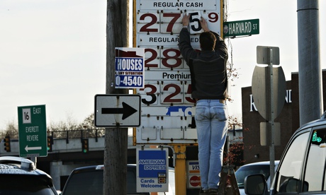 Man changing prices at a petrol station