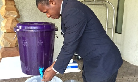 Man washing at tap in Sierra Leone