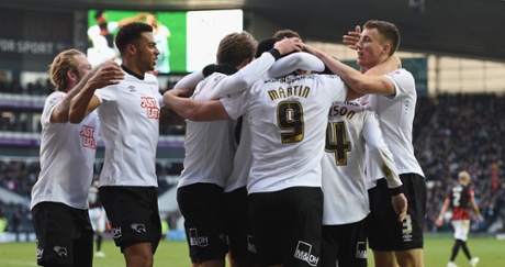 Chris Martin and team mates celebrate their third goal.